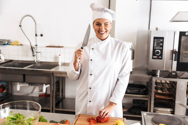 Photo of caucasian woman chef wearing white uniform making salad - Foto, Imagen