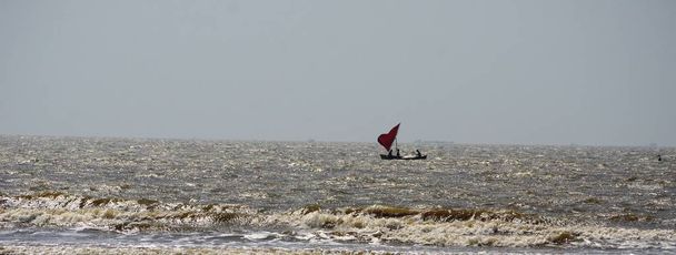 Rood gekleurde zeilboot in de Arabische Zee in de buurt van fort - Foto, afbeelding