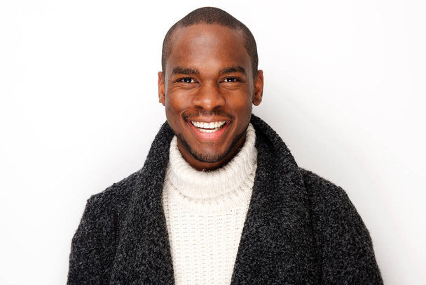 Close up portret van glimlachende jonge zwarte man met jas door geïsoleerde witte achtergrond - Foto, afbeelding