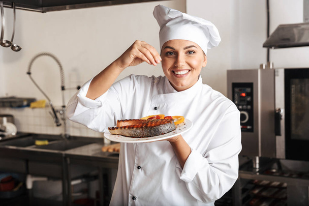 Kuva iloinen nainen kokki yllään valkoinen univormu, tilalla levy
  - Valokuva, kuva