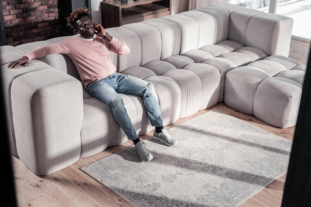 Relaxed international male person sitting on sofa - Foto, Imagem