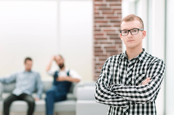 serious young man standing in spacious office - Foto, imagen