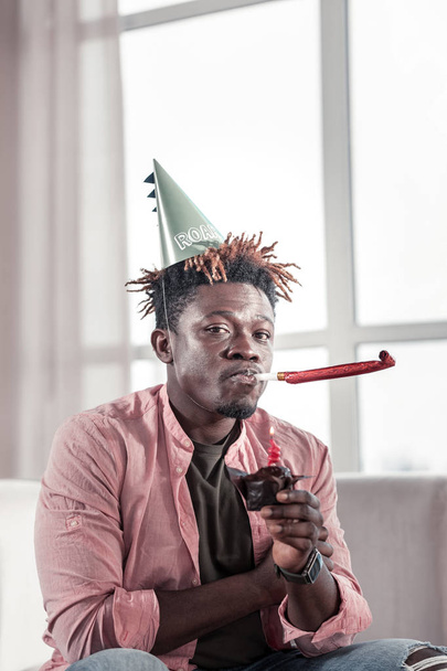 Young dark-skinned man trying to celebrate his birthday - Φωτογραφία, εικόνα