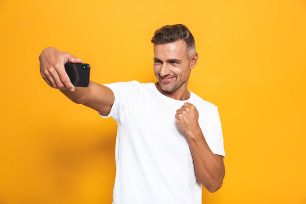 Image of caucasian man 30s in white t-shirt gesturing and taking - Φωτογραφία, εικόνα