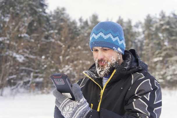 Бородатый путешественник с возмущением смотрит в телефон, так как сигнала сотовой связи нет
 - Фото, изображение