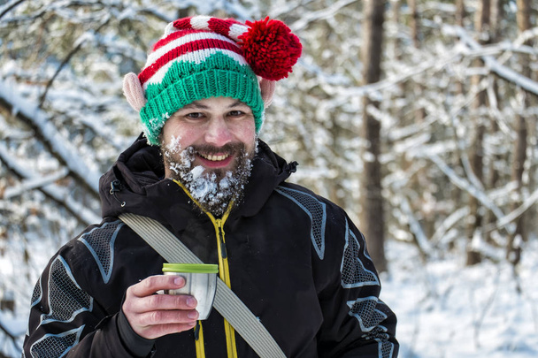 Elfo di Natale barbuto di neve che tiene una tazza di tè caldo e ride
 - Foto, immagini