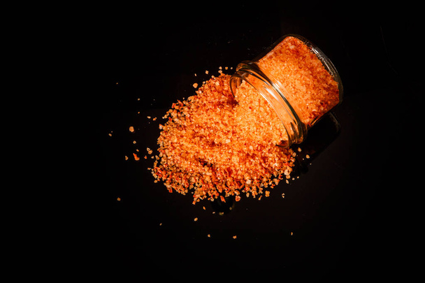 duży pomarańczowy soli organicznych wylana z mały słoik - Zdjęcie, obraz