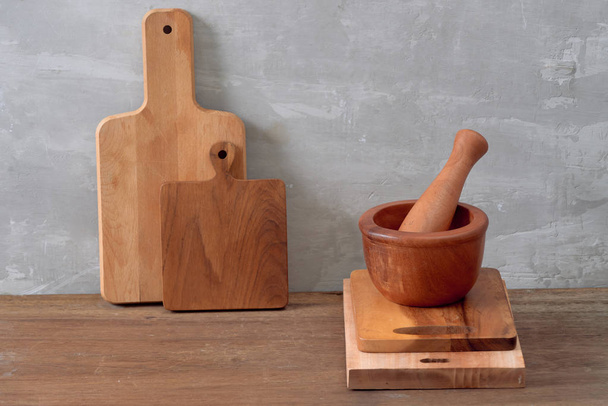 Кухонні інструменти для приготування їжі на дерев'яному столі на фоні бетонної стіни. Копіювати простір
 - Фото, зображення