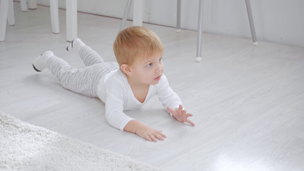 Niedlicher Kleinkind Junge krabbelt auf Knien mit Bauklötzen und fällt dann um - Filmmaterial, Video