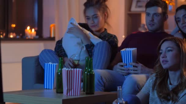 friends with beer and popcorn watching tv at home - Záběry, video