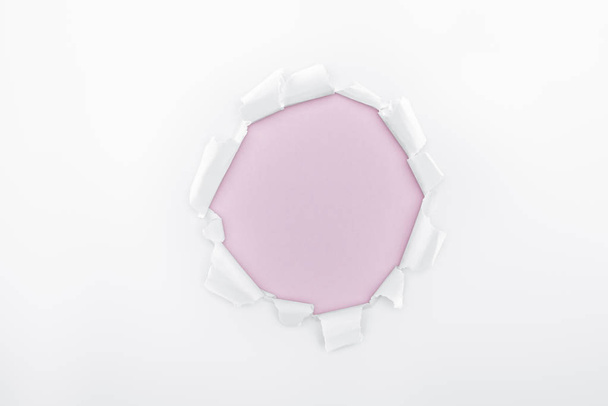 ripped hole in white textured paper on pink background  - Foto, imagen