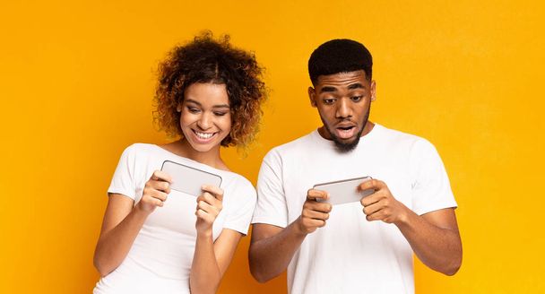Емоційний афроамериканський чоловік і жінка дивитися відео онлайн
 - Фото, зображення
