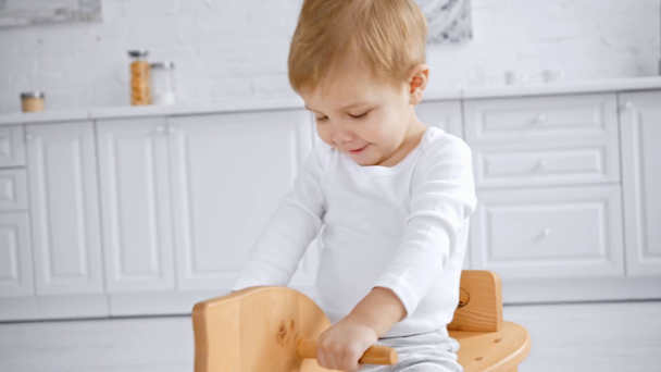 cute toddler boy laughing and riding wooden rocking horse at home  - Footage, Video