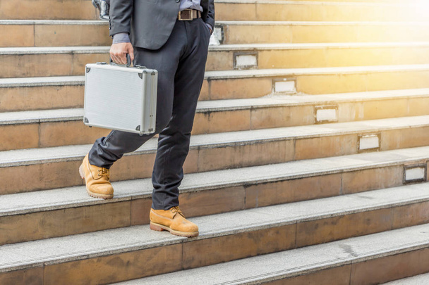 Businessman walking down stairs with bags to office. - Photo, image