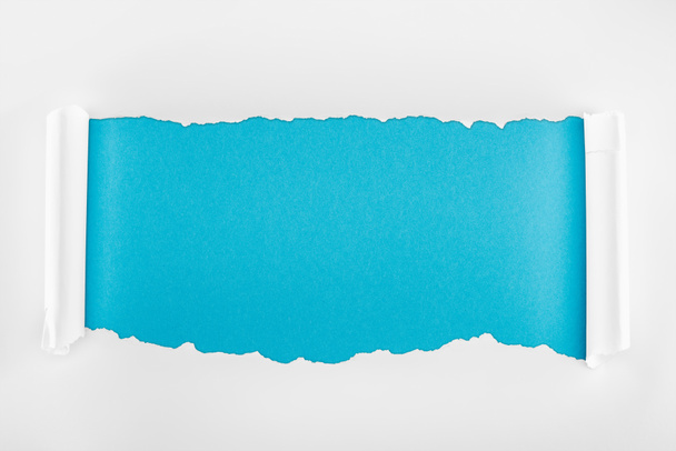 zgrywanie białego papieru z zagięciem krawędzi na niebieskim tle  - Zdjęcie, obraz