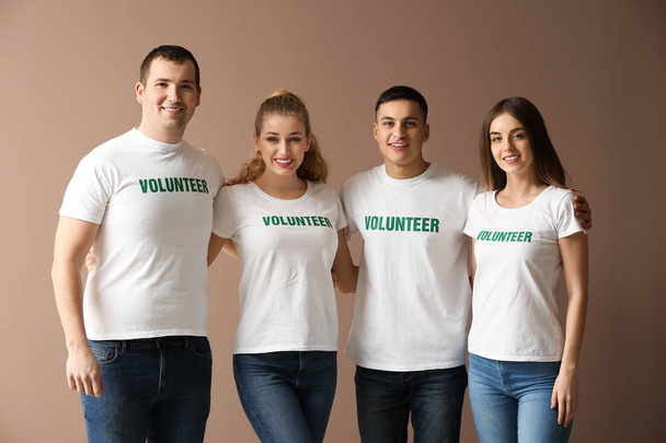 Team of young volunteers on color background - Фото, изображение