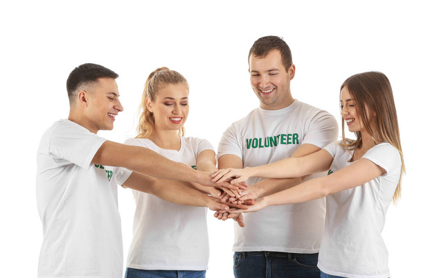 Zespół młodych wolontariuszy wprowadzenie ręce razem na białym tle - Zdjęcie, obraz