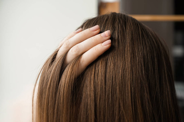Νεαρή γυναίκα με υγιή μακριά μαλλιά, κοντινό πλάνο - Φωτογραφία, εικόνα