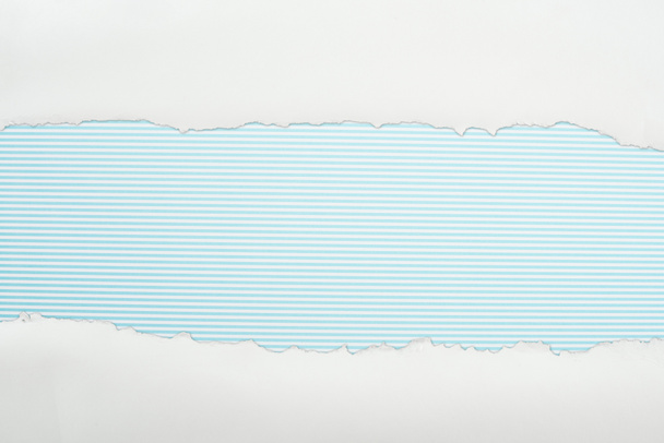 zerlumptes weißes strukturiertes Papier mit Kopierraum auf hellblau gestreiftem Hintergrund  - Foto, Bild