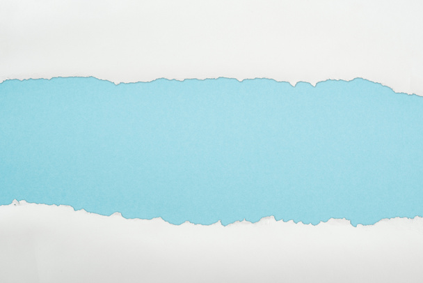 ragged white and textured paper with copy space on light blue background  - Foto, Bild