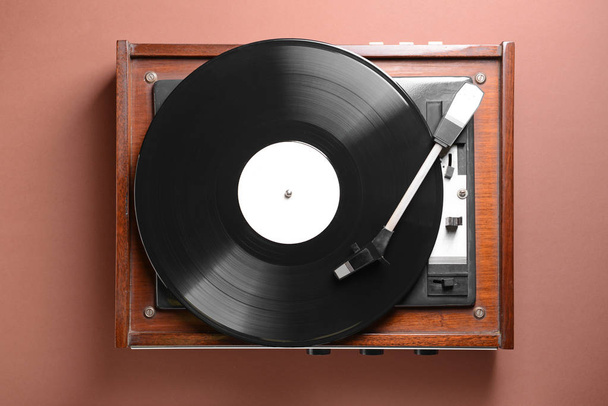 Record player with vinyl disc on color background - Foto, Imagen