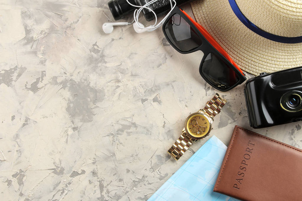Seyahat kavramı şapka, pasaport, harita, fotoğraf makinesi ve hafif bir beton zemin üzerine güneş gözlüğü. Üstten Görünüm - Fotoğraf, Görsel