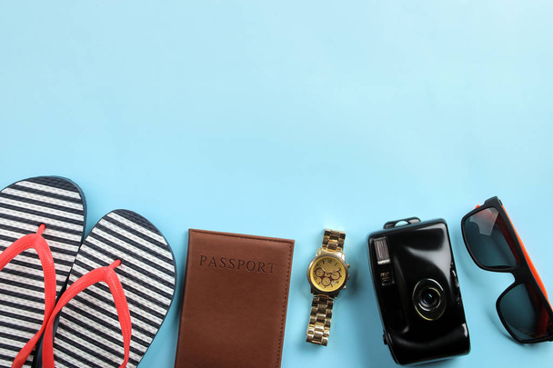 Concepto de viaje. cámara, pasaporte, chanclas y gafas sobre un fondo azul brillante. vista superior
. - Foto, imagen