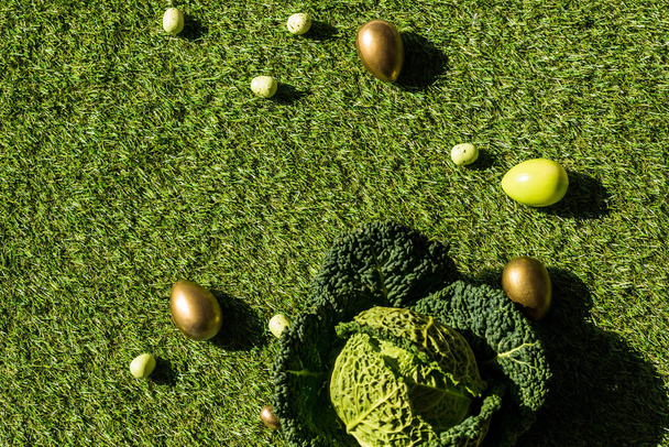 yeşil çim üzerinde renkli tavuk ve bıldırcın yumurtaları ve Savoy lahana üst görünümü   - Fotoğraf, Görsel