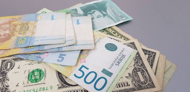 закрытие банкнот гривневых динаров и долларов на сером фоне
 - Фото, изображение