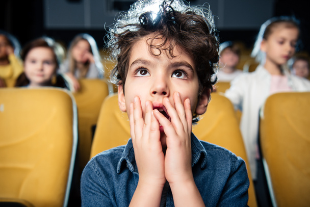 επιλεκτική εστίαση έκπληκτος Μικτή φυλή αγόρι βλέποντας ταινίες μαζί με τους φίλους - Φωτογραφία, εικόνα
