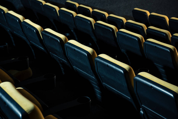 rows of comfortable plastic empty seats in cinema hall  - Фото, изображение