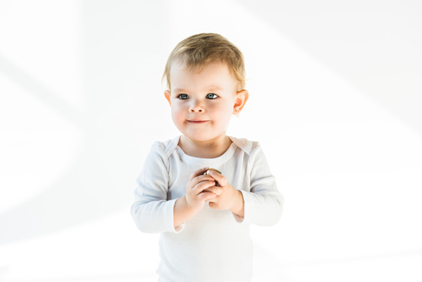 adorable bebé de ensueño con cabello rubio mirando hacia otro lado aislado en blanco
 - Foto, Imagen