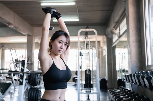 Exercise concept. A beautiful girl is exercising in the gym. Asi - 写真・画像