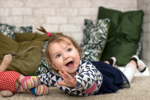 mooi baby meisje, zuigen haar duim en knuffelen haar pop klaar voor bed - Foto, afbeelding