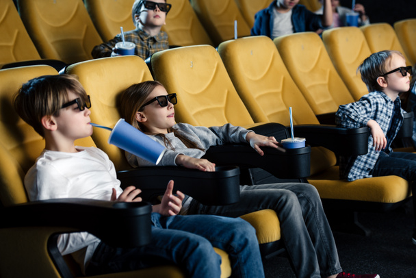 friends in 3d glasses watching movie in cinema and holding paper cups - Photo, Image