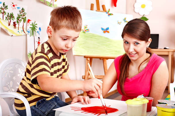 gyermek a tanár felhívja a festékek játék szoba. - Fotó, kép