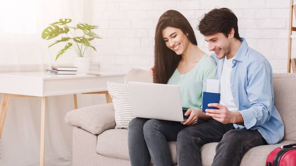 Περιοδεία σχεδιασμού. Ευτυχισμένο ζευγάρι χρησιμοποιώντας το laptop στο σπίτι - Φωτογραφία, εικόνα