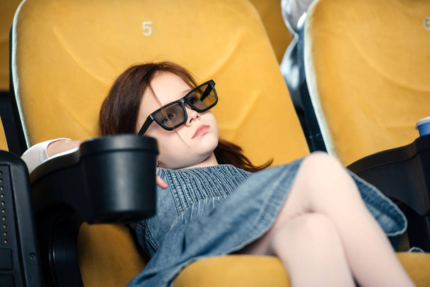 selective focus of dreamy child in 3d glasses sitting in cinema seat - Photo, Image