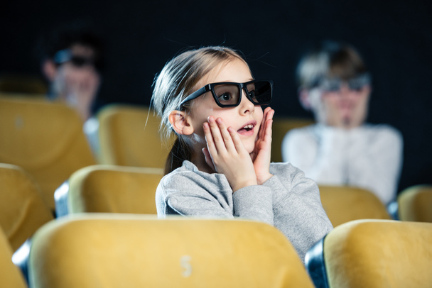 Selektywny fokus martwi się dziecka w okulary 3d, trzymając ręce na twarzy podczas oglądania filmu - Zdjęcie, obraz