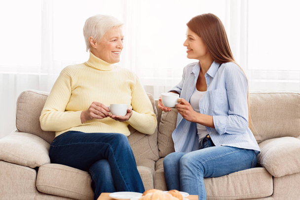 Senior mom and adult daughter talking and drinking coffee - Φωτογραφία, εικόνα