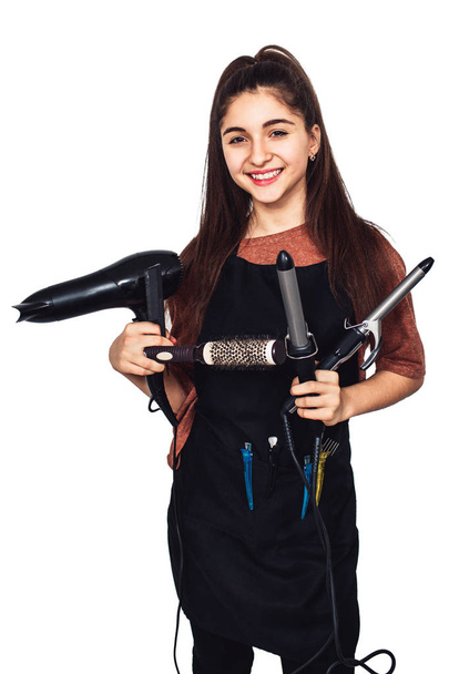 young girl hairdresser with a curling iron, hairdryer, comb. - Photo, Image