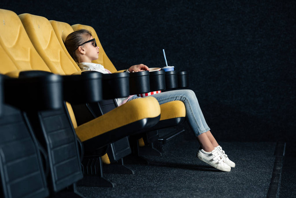 selective focus of child sitting in cinema seat with paper cup - Photo, Image