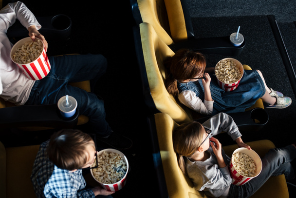 映画館で紙コップを食べる 3 d メガネで子供のオーバー ヘッド ビュー  - 写真・画像