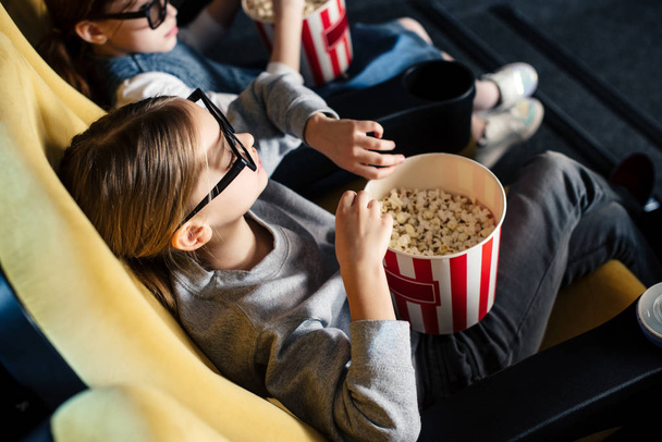 cute children in 3d glasses watching movie and eating popcorn in cinema - Fotoğraf, Görsel