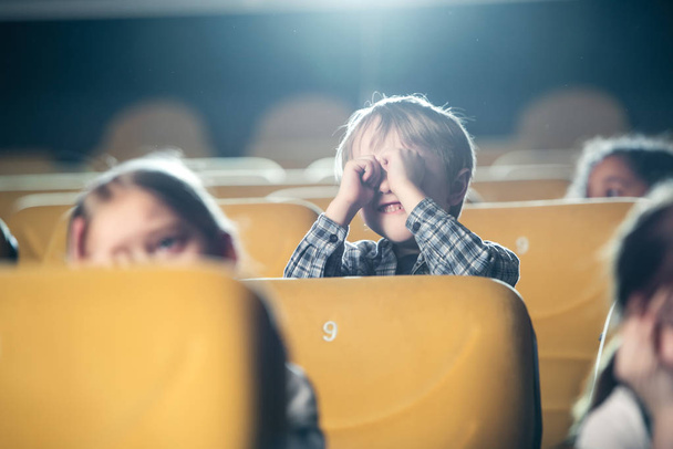 enfoque selectivo de lindo niño sosteniendo muñecas cerca de gafas mientras ve la película con amigos multiculturales
 - Foto, imagen