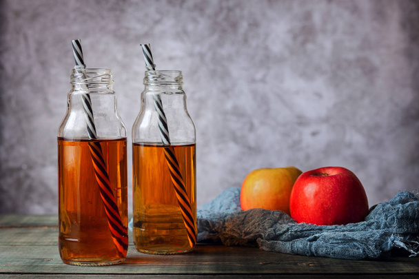 On the table is apple juice in a glass bottle - 写真・画像