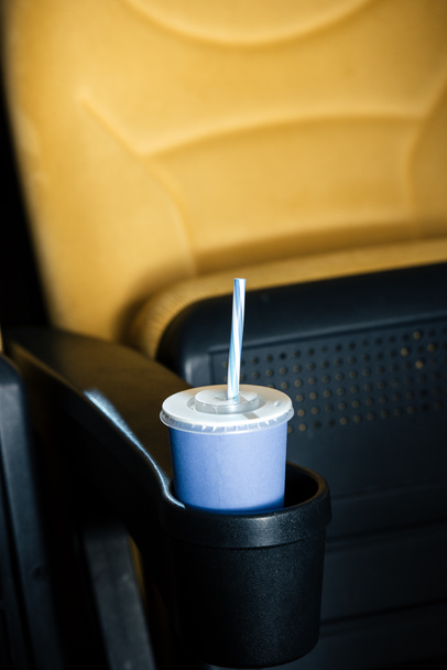 Mavi tek kullanımlık bardak bardak tutucu saman ile sinema koltuğu seçici odak - Fotoğraf, Görsel