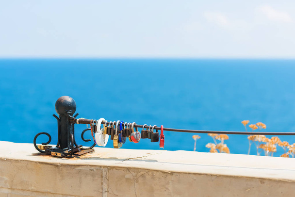 Colored locks on the bridge. Rest in Crimea. Metal handrail on which the locks hang. Black Sea. - Photo, Image