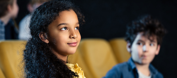 plano panorámico del niño afroamericano viendo la película junto con un amigo de raza mixta
 - Foto, Imagen