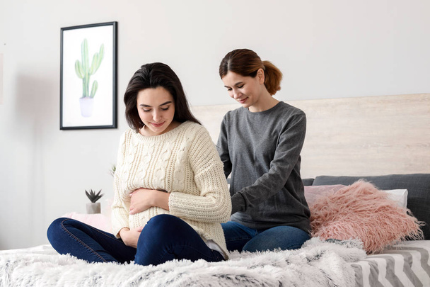 Doula massaging pregnant woman at home - Foto, afbeelding